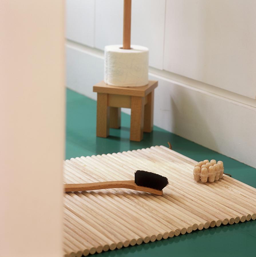 A Brush On A Wooden Mat And A Toilet Roll Holder Photograph by Simon Scarboro