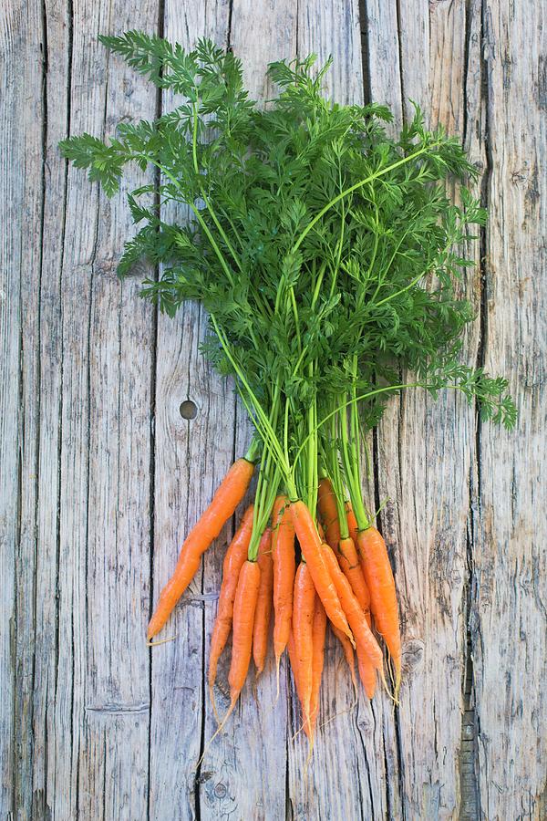 A Bunch Of Baby Carrots On A Wooden Surface top View Photograph by Tina Engel