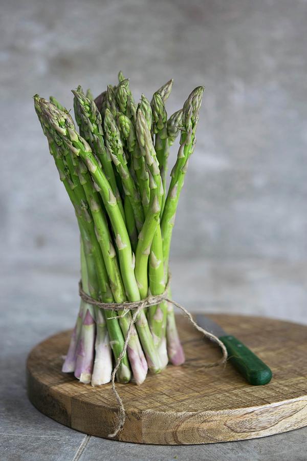 A Bunch Of Fresh Asparagus On A Wooden Board Photograph by Justina Ramanauskiene