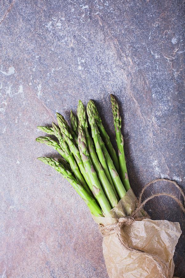 A Bunch Of Fresh Asparagus Spears In A Paper Bag Tied With String Photograph by Rose Hewartson