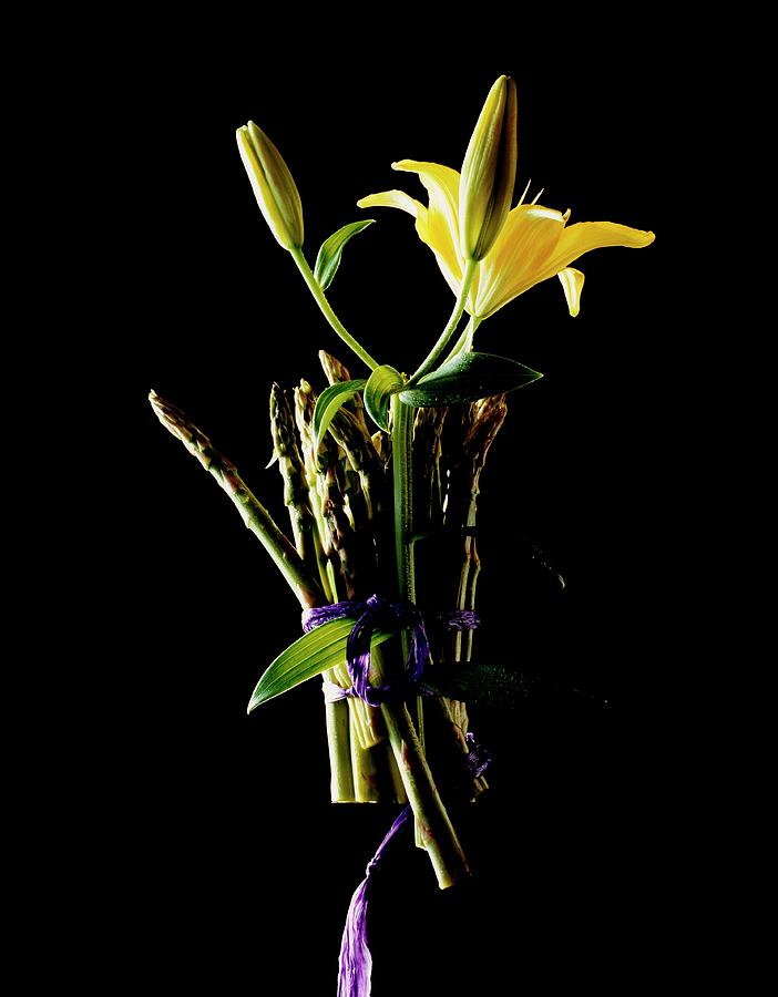 A Bunch Of Green Asparagus And Yellow Lilies Against A Black Background Photograph by Michael Wissing