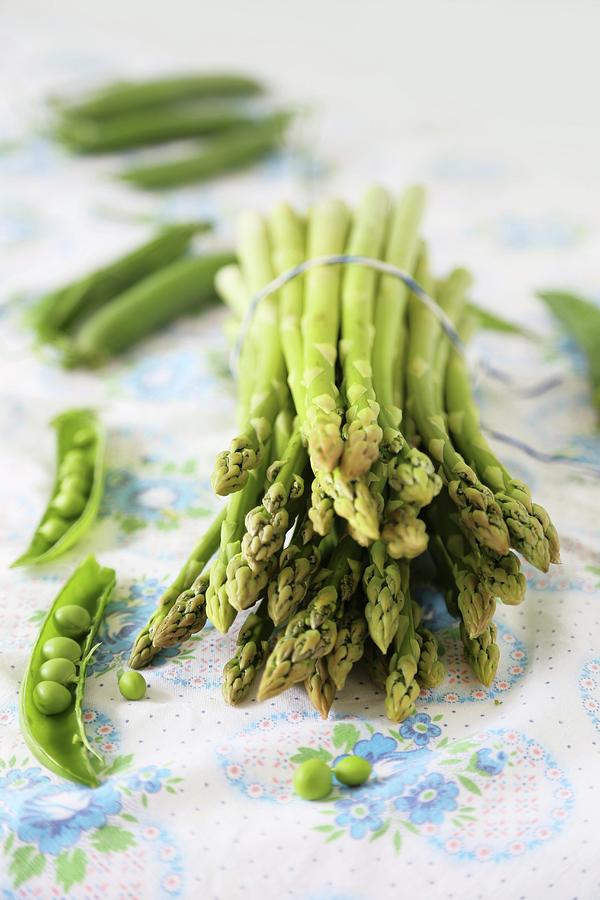 A Bunch Of Green Asparagus Surrounded By Peapods Photograph by Syl Loves
