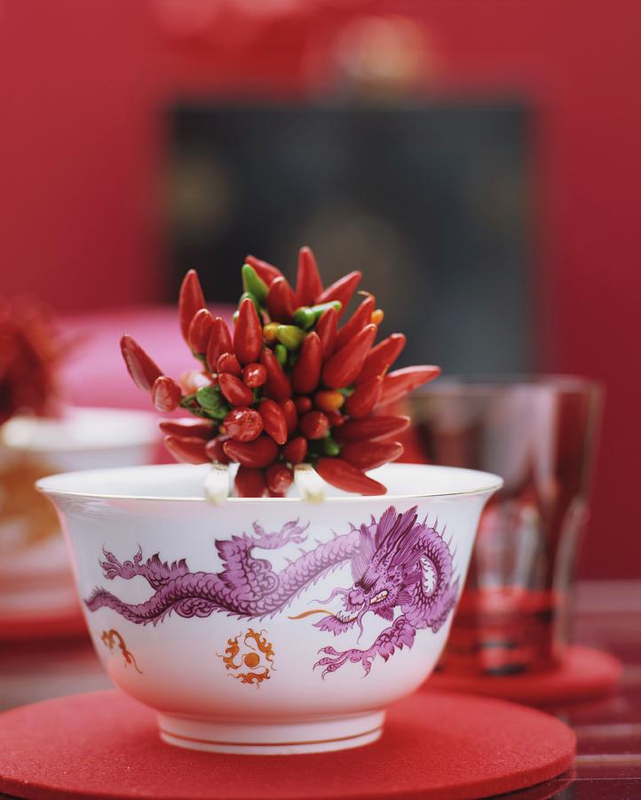 A Bundle Of Chilli Peppers In A Porcelain Bowl With A Dragon Motif Photograph by Matteo Manduzio