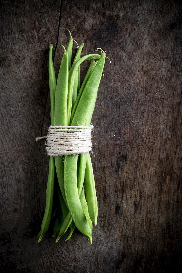 A Bundle Of Green Beans On A Wooden Board Photograph by Nitin Kapoor