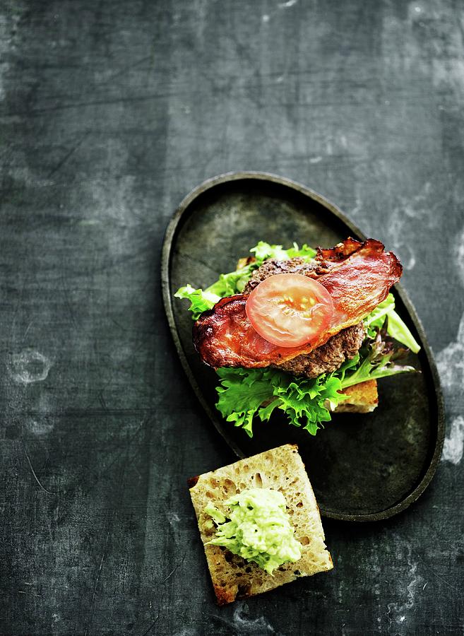 A Burger On A Roll With Crispy Bacon And Lettuce Photograph by Mikkel Adsbl