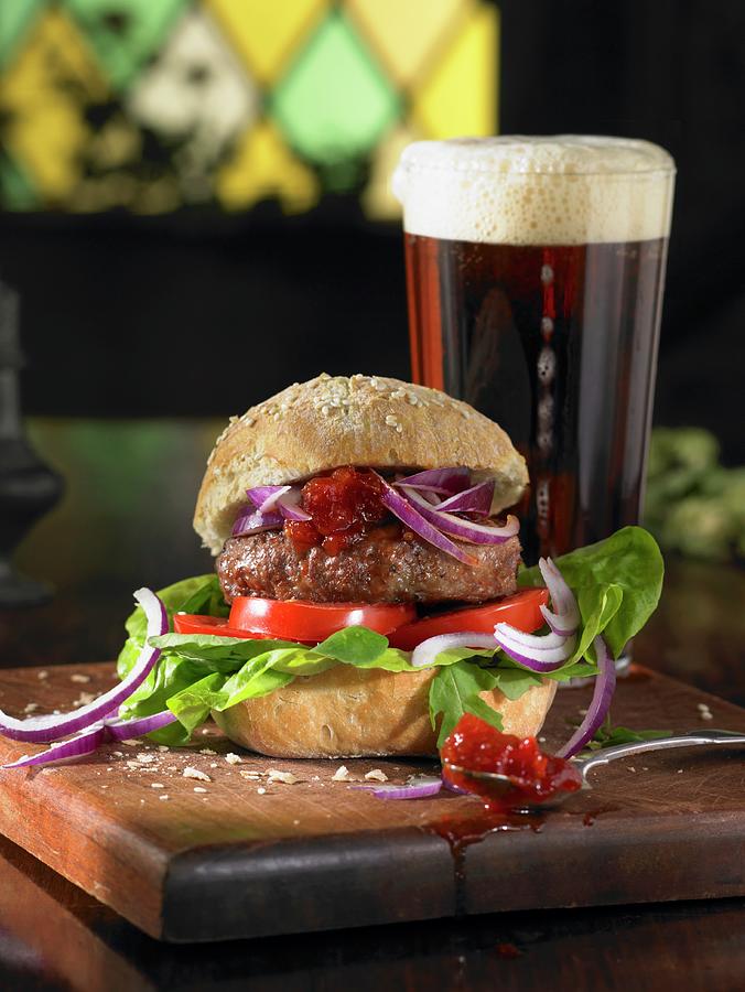 A Burger With Lettuce, Tomatoes, Red Onions And Chutney Served With A Pint Of Ale Photograph by Atkinson / Sue Dr.