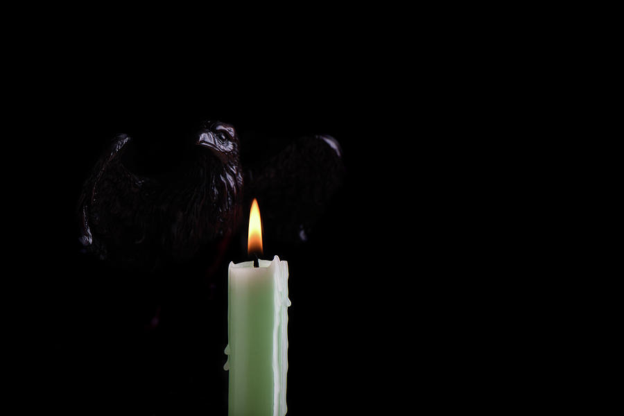 A Burning Pale Green Candle Illuminates The Shape Of An Eagle, Isolated Against A Black Background. Pyrography