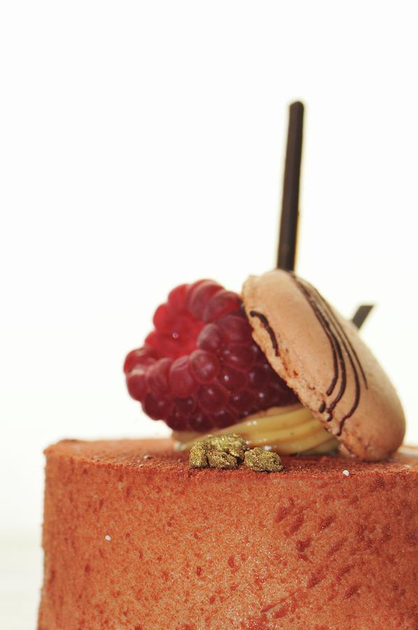 A Cake Topped With A Raspberry And A Macaroon close-up Photograph by Jean-claude Tabernier