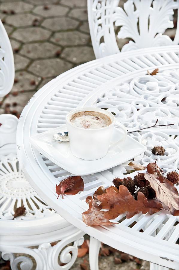 A Cappuccino On A Table With Autumnal Leaves Photograph by Atelier Hmmerle