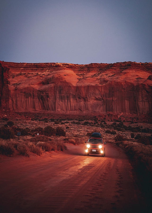 Nature Photograph - A Car Is On The Road In The Middle Of The Monument Valley, Arizona, Us by Cavan Images