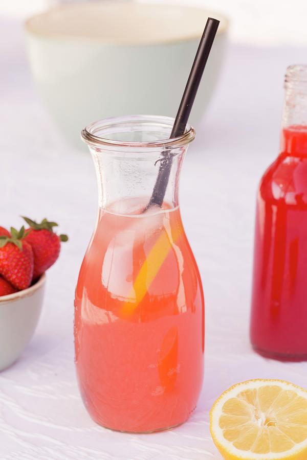 A Carafe Of Homemade Rhubarb And Strawberry Lemonade With Lemons Photograph by Esther Hildebrandt