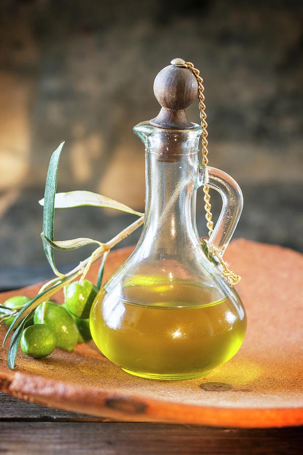 A Carafe Of Olive Oil And A Sprig Of Green Olives Photograph by Natasha Breen