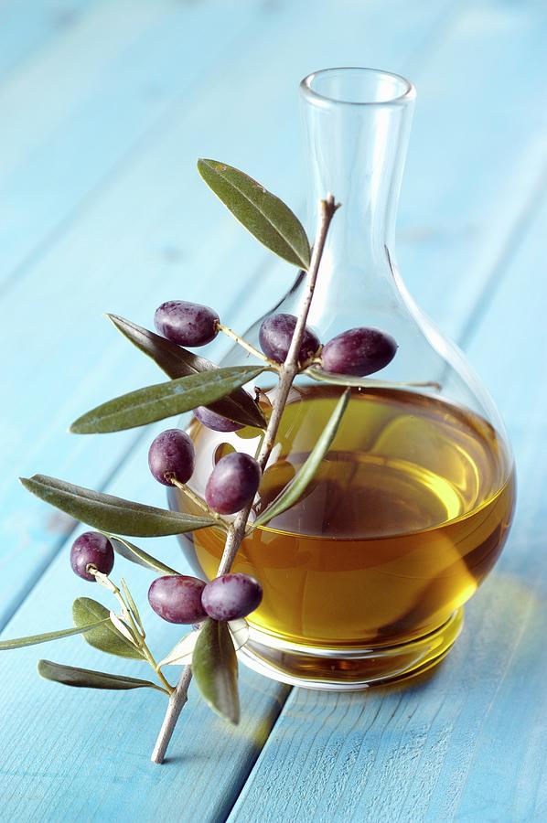 A Carafe Of Olive Oil And A Sprig Of Olives Photograph by Franco Pizzochero