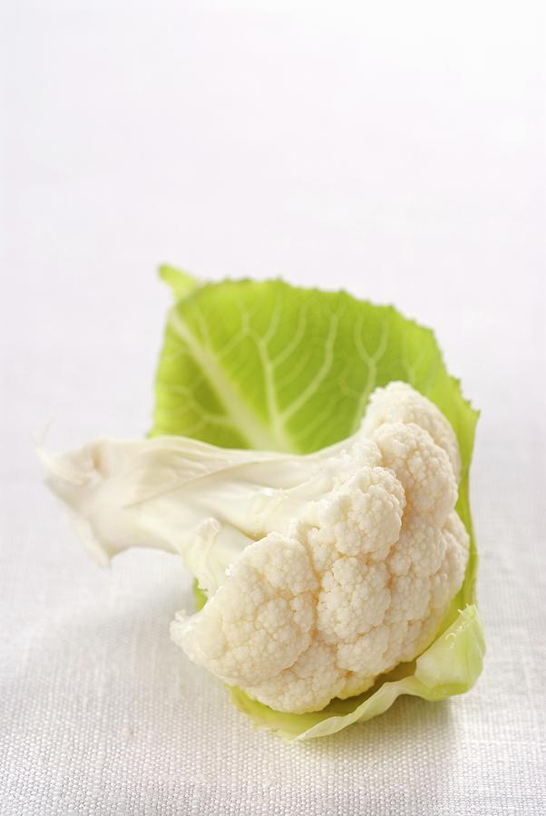 A Cauliflower Floret With A Leaf Photograph by Franco Pizzochero