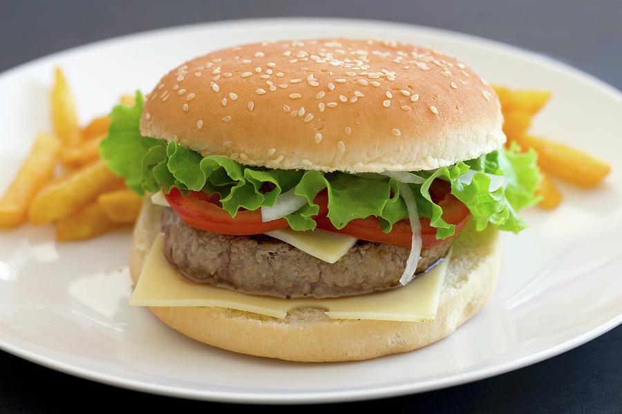 Potato Photograph - A Cheeseburger With Tomatoes And Lettuce by Lydie Besancon