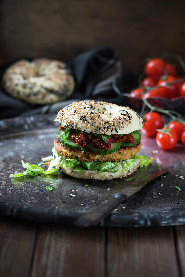 A Chickpea And Courgette Fritter In A Sesame Seed Bagel With Dried Tomatoes, Lettuce And Cucumber vegan Photograph by Kati Neudert