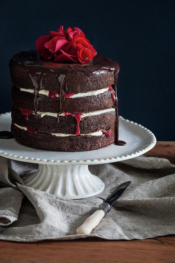 A Chocolate Cake With Raspberry Jam, Chocolate Glaze And Rose Petals Photograph by The Food Union