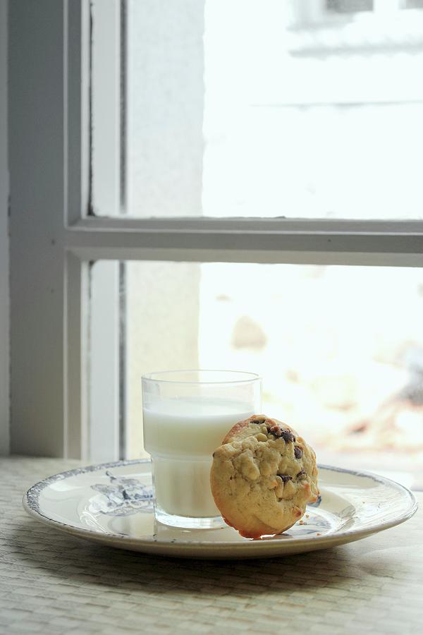 A Chocolate Chip Cookie And A Glass Of Milk In Front Of A Window Photograph by Patricia Miceli