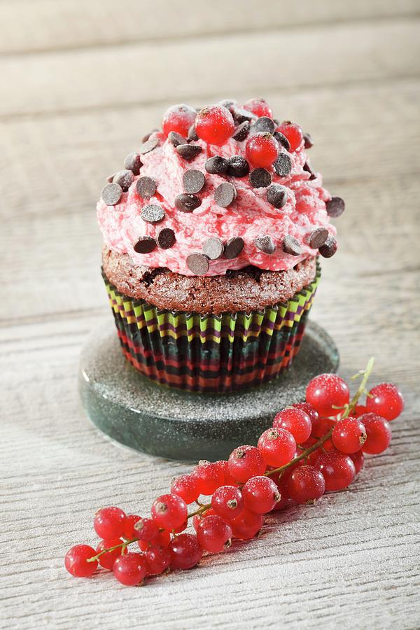 A Chocolate Cupcake Decorated With Strawberry Cream, Chocolate Pearls And Redcurrants Photograph by Niklas Thiemann