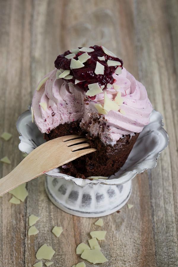 A Chocolate Cupcake Topped With Blueberry Cream With A Bite Taken Out Photograph by Esther Hildebrandt