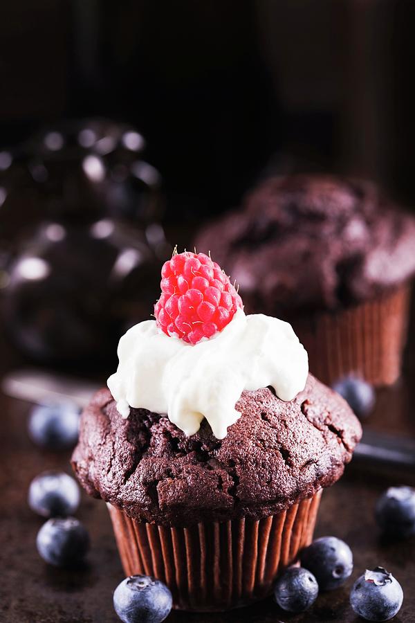 A Chocolate Cupcake With Cream And A Raspberry Photograph by Ilya Shapovalov