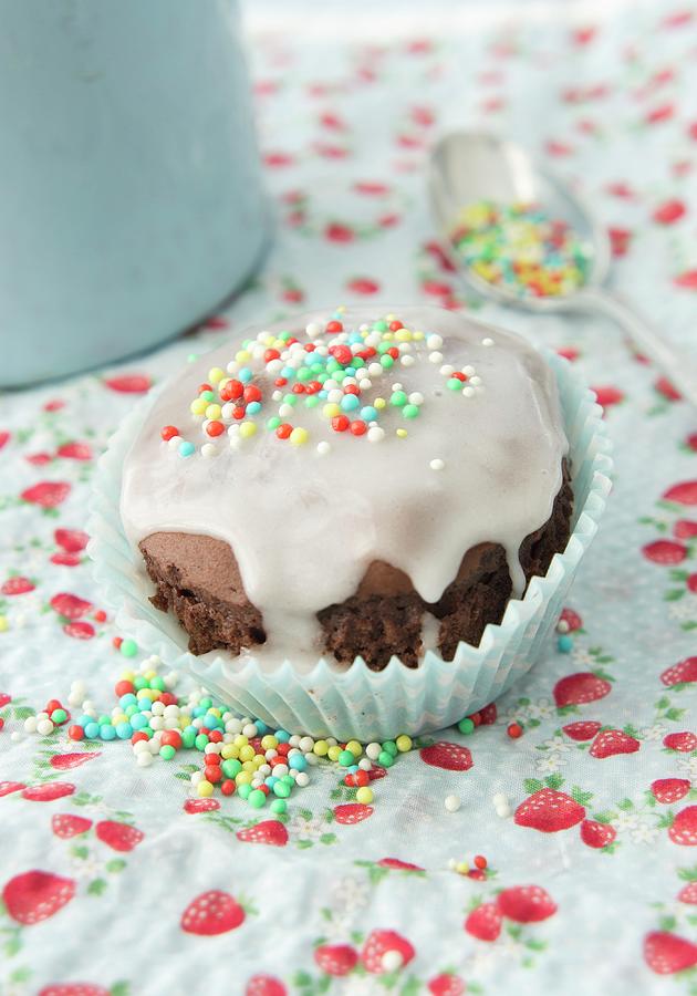 A Chocolate Muffin With Icing And Sugar Sprinkles Photograph by Martina Schindler
