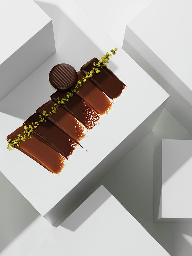 A Chocolate Praline On Various Chocolate Textures With Pistachios Photograph by Armin Zogbaum