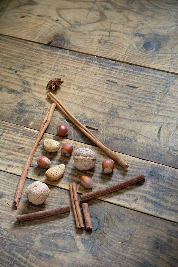 A Christmas Tree Made From Nuts, Anise Stars And Cinnamon Sticks On A Wooden Table Photograph by Achim Sass