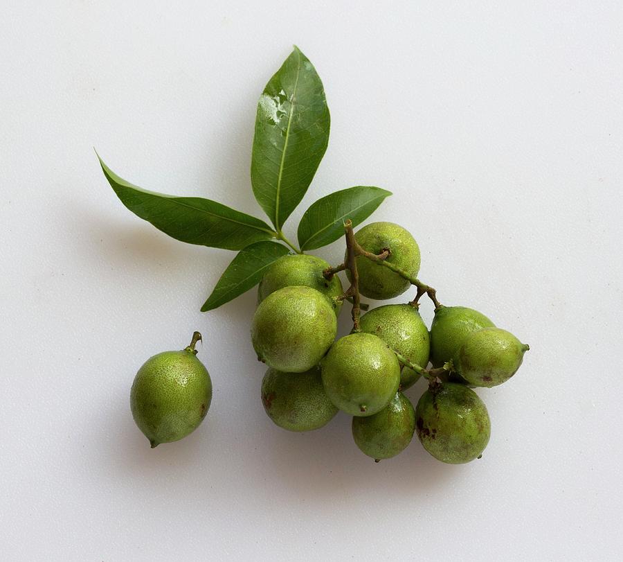 A Cluster Of Quenepas also Known As Spanish Limes, Genip Or Kenips On A White Surface Photograph by Albert P Macdonald