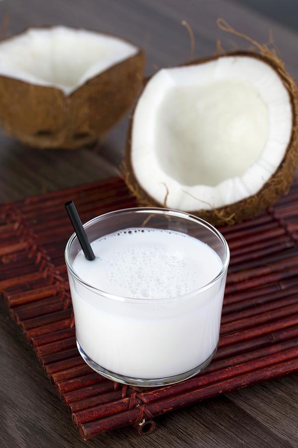 A Coconut Milk Drink In A Glass With A Straw Photograph by Lydie Besancon