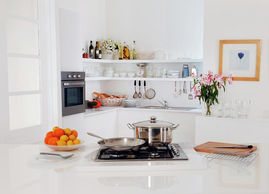 A Contemporary White Kitchen With A Gas Hob And Various Cooking Utensils Photograph by Foodfolio