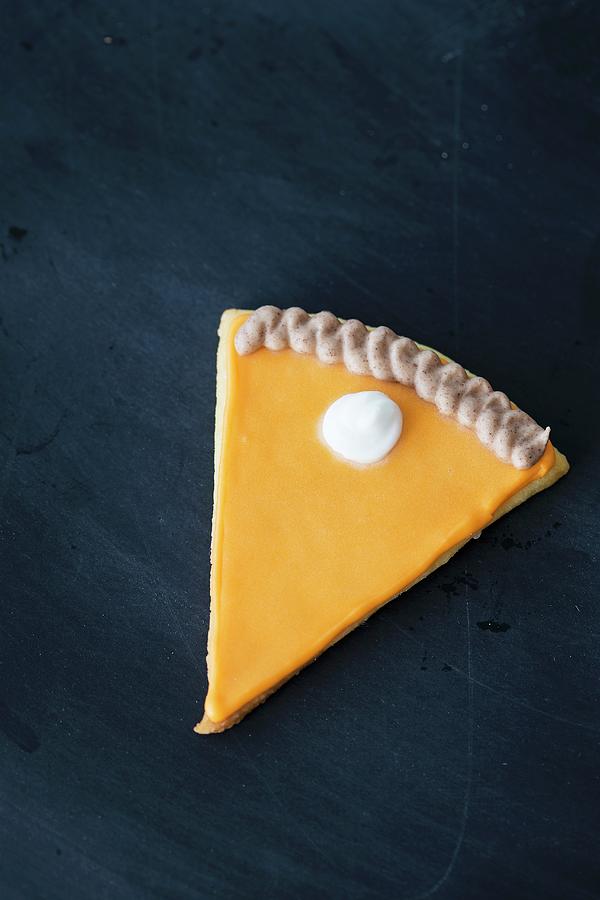 A Cookie In The Shape Of A Slice Of Pumpkin Pie With Icing Photograph by Malgorzata Laniak