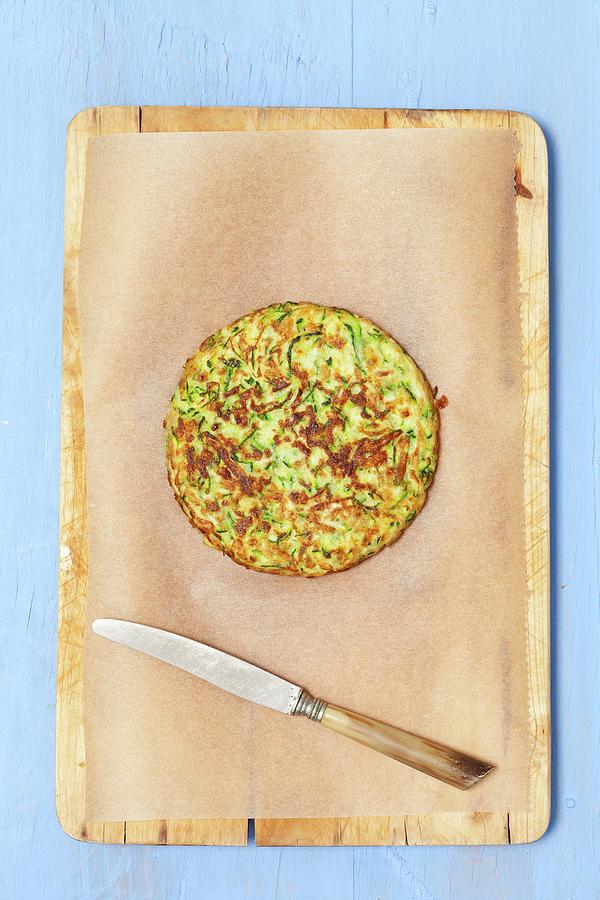 A Courgette Cake On Baking Paper With A Knife Photograph by Rua Castilho