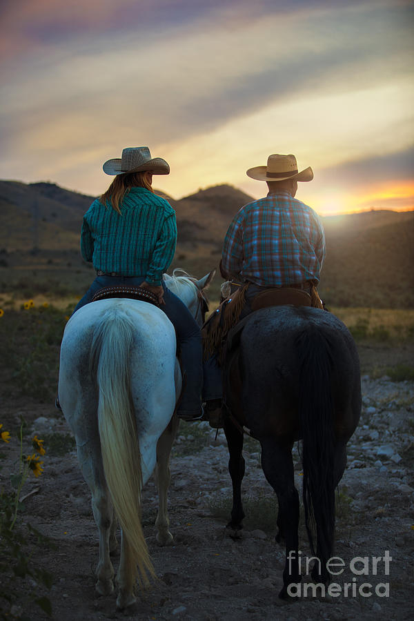 A Cowboy and a Cowgirl on Horseback at Sunset Photograph by Diane Diederich
