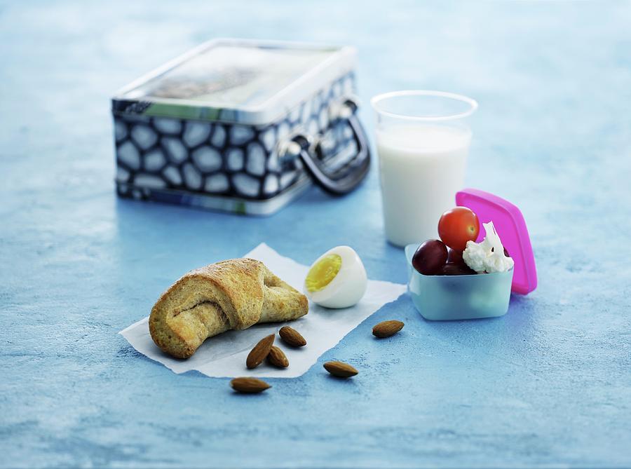 A Croissant, A Hard-boiled Eggs, Almonds, Fruit, Vegetables And Milk For Lunch Photograph by Mikkel Adsbl