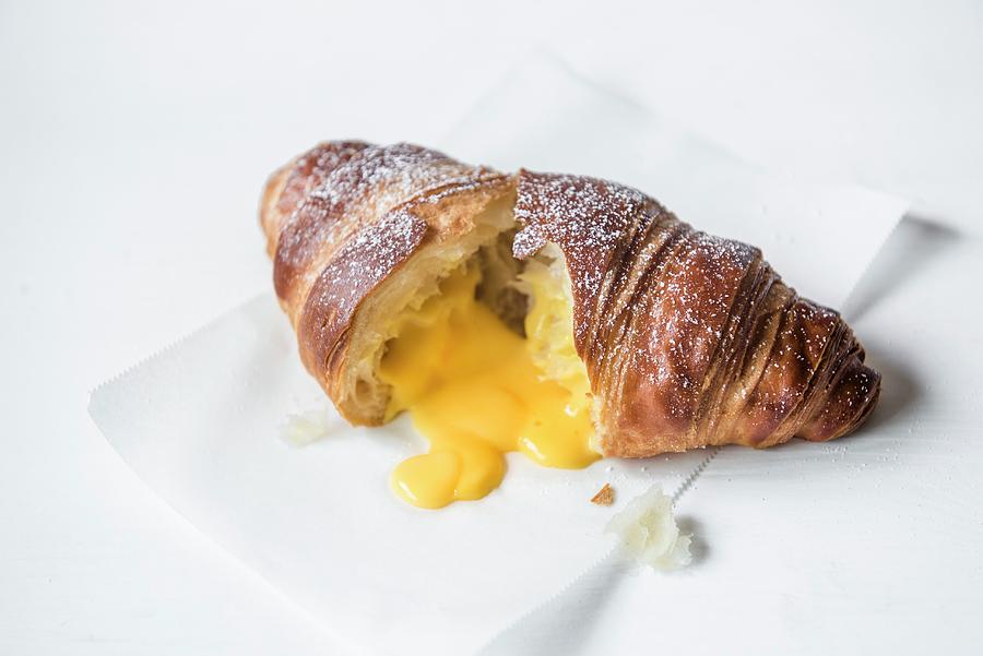 A Croissant Filled With Salted Egg Yolk Cut Open On A Baking Parchment Photograph by Magdalena Hendey