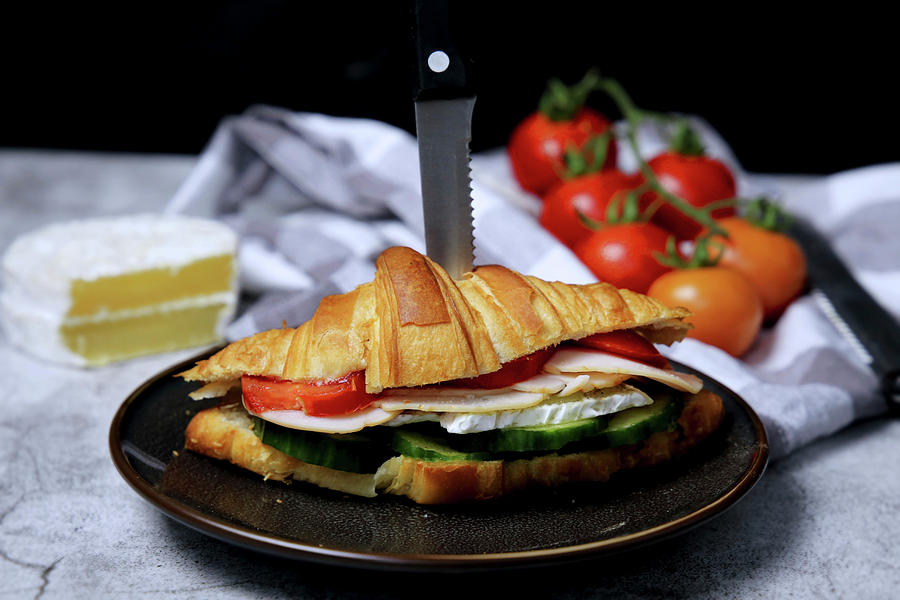 A Croissant Sandwich With Cucumber, Cheese, Sausage And Tomatoes Photograph by Sarahs Foodphotos