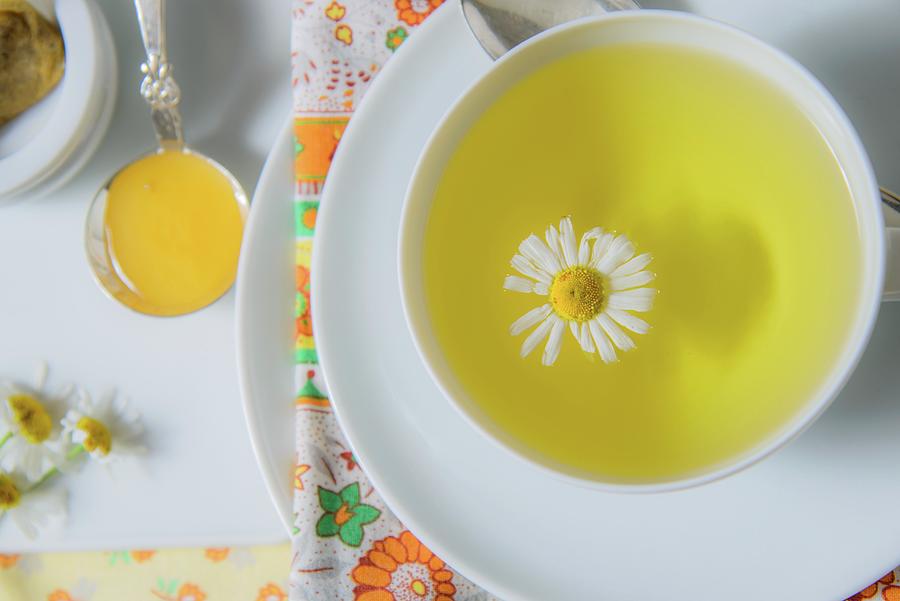 A Cup Of Chamomile Tea With A Chamomile Flower seen From Above Photograph by Katrin Benary