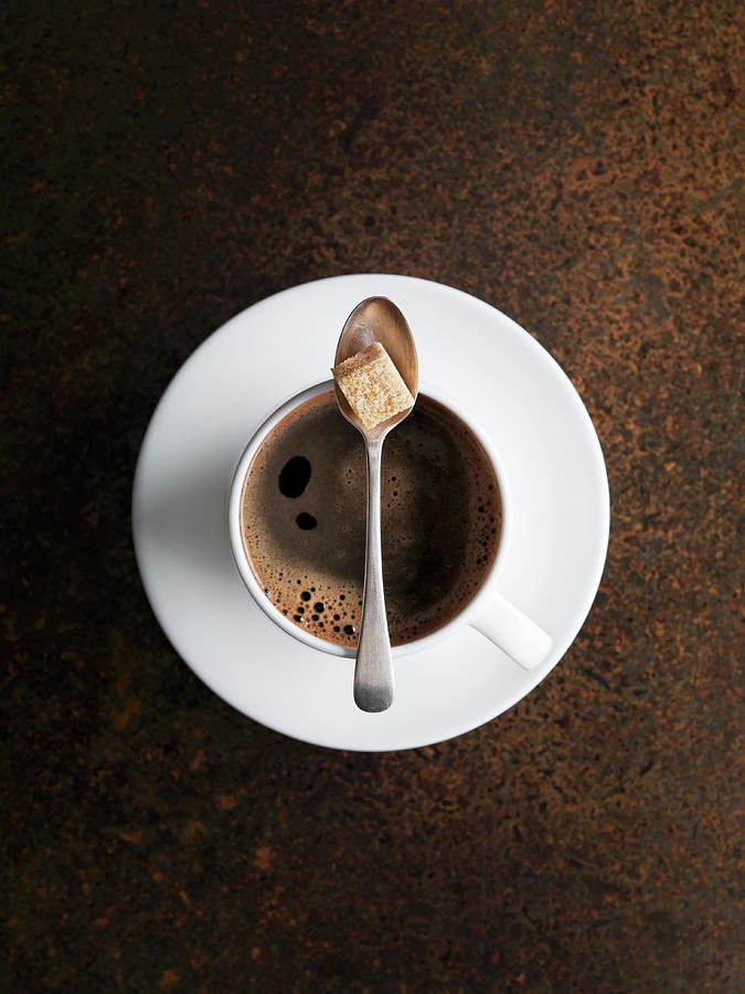 A Cup Of Coffee With A Spoon And Sugar Cube Photograph by Jonathan Gregson