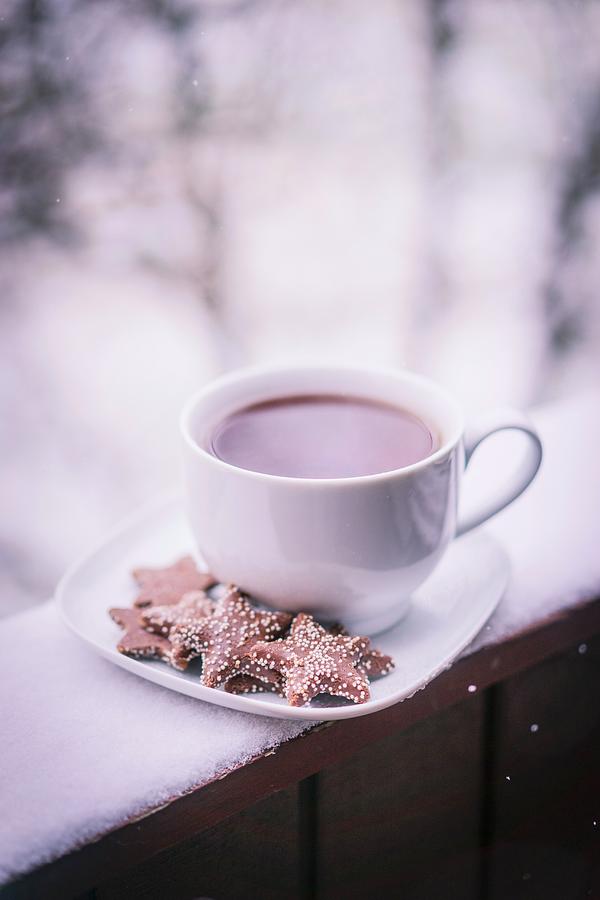 Tea Photograph - A Cup Of Hot Tea With Biscuits On A Saucer On A Snow-covered Balcony by Alena Haurylik