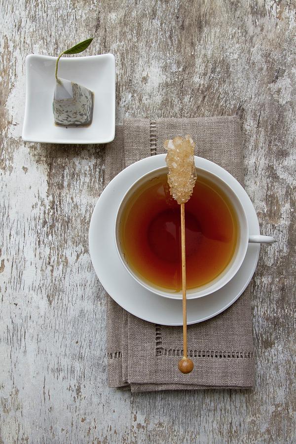 A Cup Of Tea With A Stick Of Rock Sugar With A Tea Bag Next To It Photograph by Catja Vedder