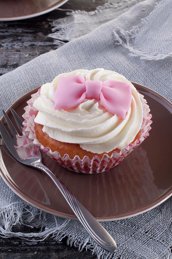 A Cupcake Decorated With A Pink Fondant Bow Photograph by Wawrzyniak.asia