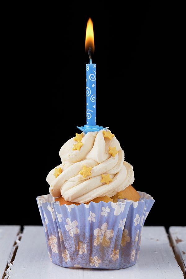 A Cupcake Decorated With Gold Stars And A Birthday Candle Photograph by Lydie Besancon