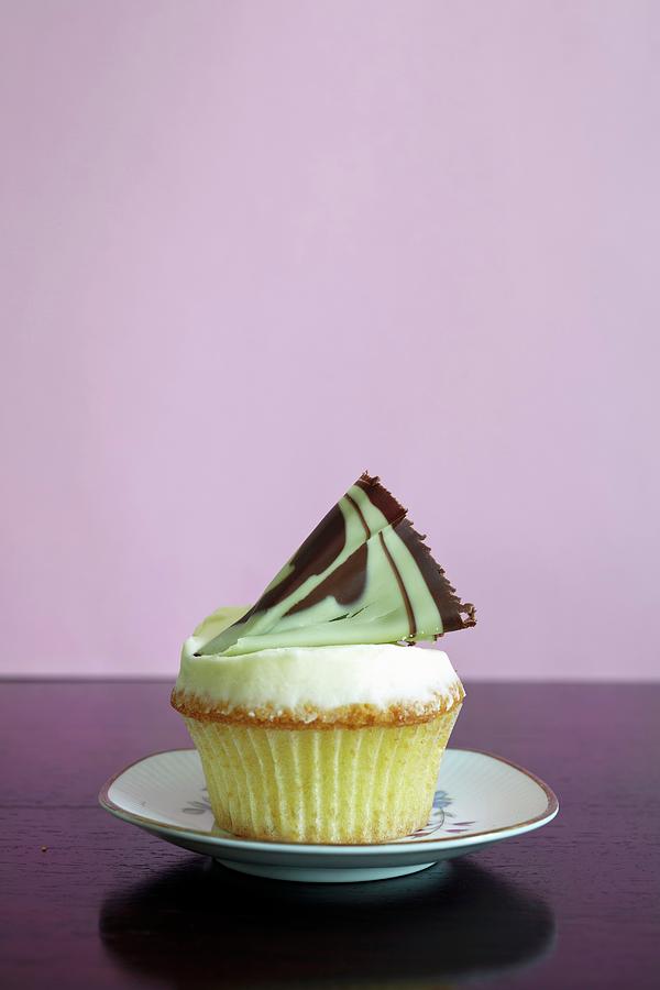 A Cupcake Topped With A Fan Of Chocolate And Pistachio Photograph by Lioba Schneider Fotodesign