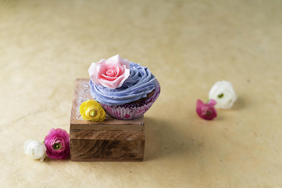 A Cupcake With Blue Cream And A Rose Blossom Photograph by Mandy Reschke