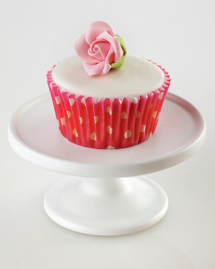 A Cupcake With White Glaze And A Sugar Rose Photograph by Foodfolio