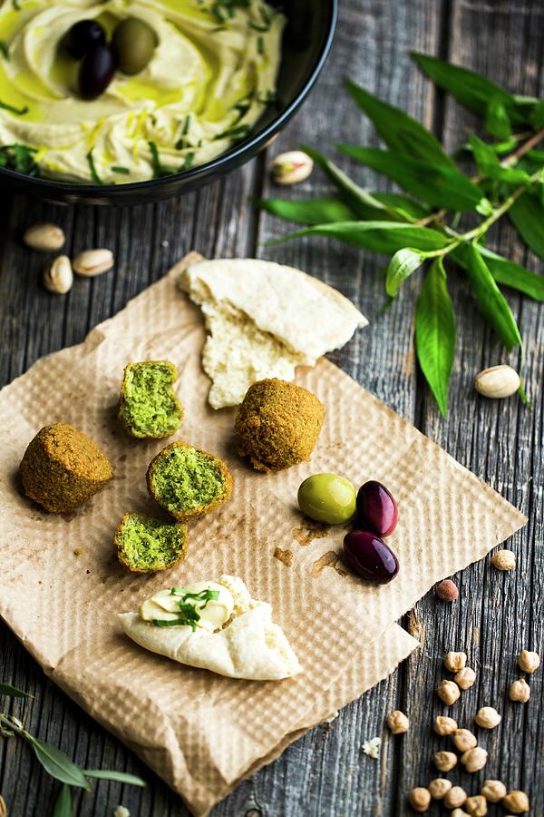 A Dish With Old Biblical Ingredients: Falafel, Flatbread, Olives, Pistachios And Hummus Photograph by Sandra Krimshandl-tauscher
