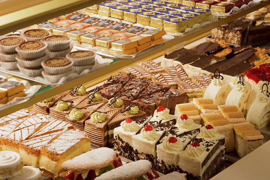 A Display Of Cakes In A Bakers Photograph by Rita Newman