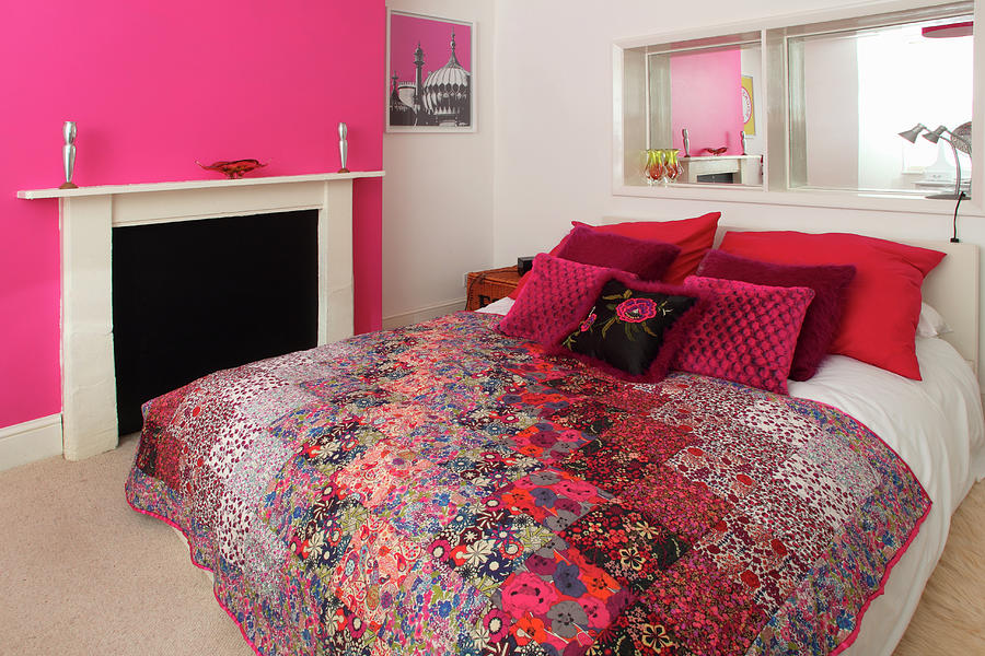 A Double Bed With Decorative Cushions And A Quilt In A Bedroom With Pink And White Walls Photograph by Steven Morris