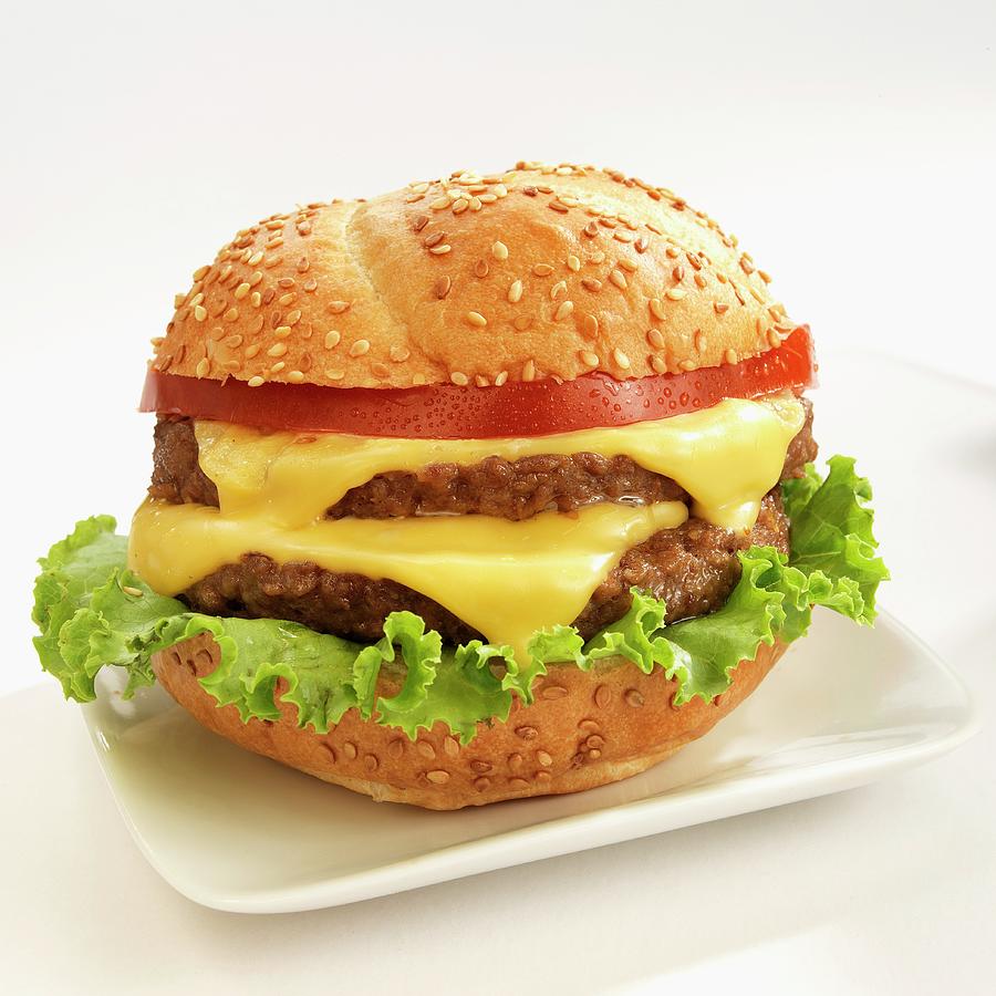 A Double Cheese Burger With Tomatoes On Sesame Seeds Bun Photograph by Paul Poplis
